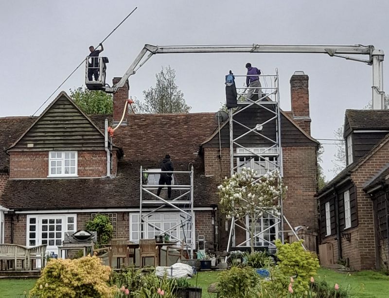 The Roof Moss Cleaners using cherry picker and scaffolding to clean roof safely and professionally in Haywards Heath, West Sussex